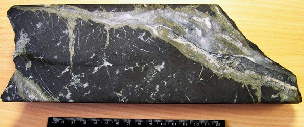 Золотоносная магнетитовая руда с кварц-кальцит-сульфидными гнездами и прожилками