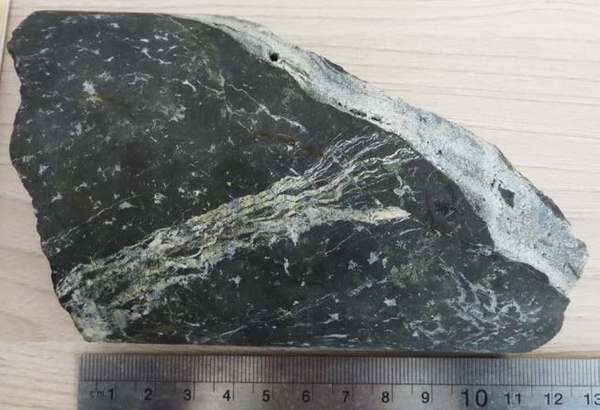 Сплошные магнетитовые руды с гнездами и прожилками кальцита, скарновых минералов